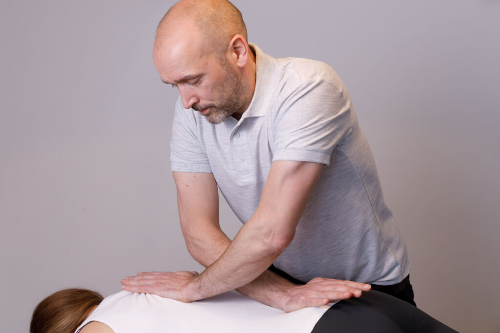 Male osteopath treating patient in Milton Keynes