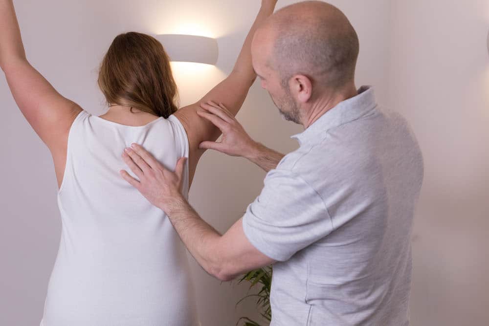 Male osteopath treating patient at Poplar Osteopathic clinic Milton Keynes