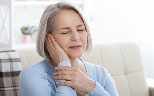 Older woman suffering from neck or jaw pain