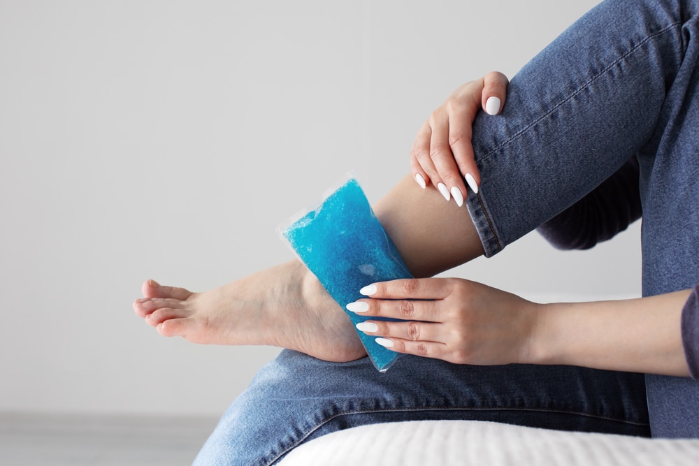 Person holding ice pack to their ankle